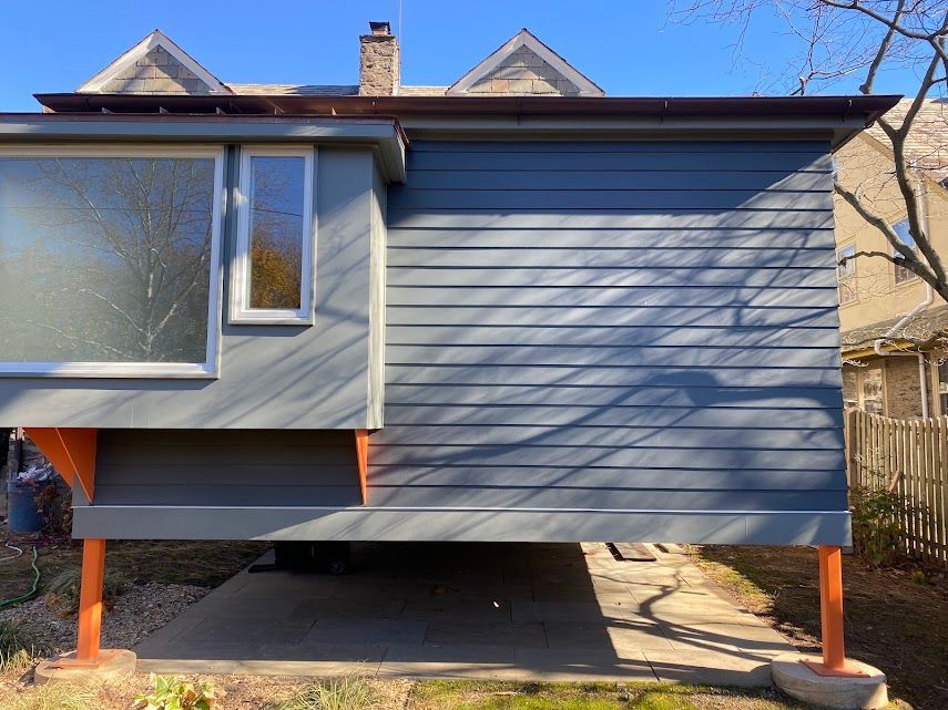 A gray residential extension with orange supports.  James McCoy Remodeling Services Serving 19072,19003,19118,19444,19095 and surrounding areas
