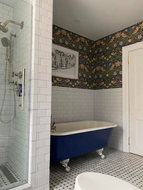 A bathroom with a blue bathtub and a walk in shower.