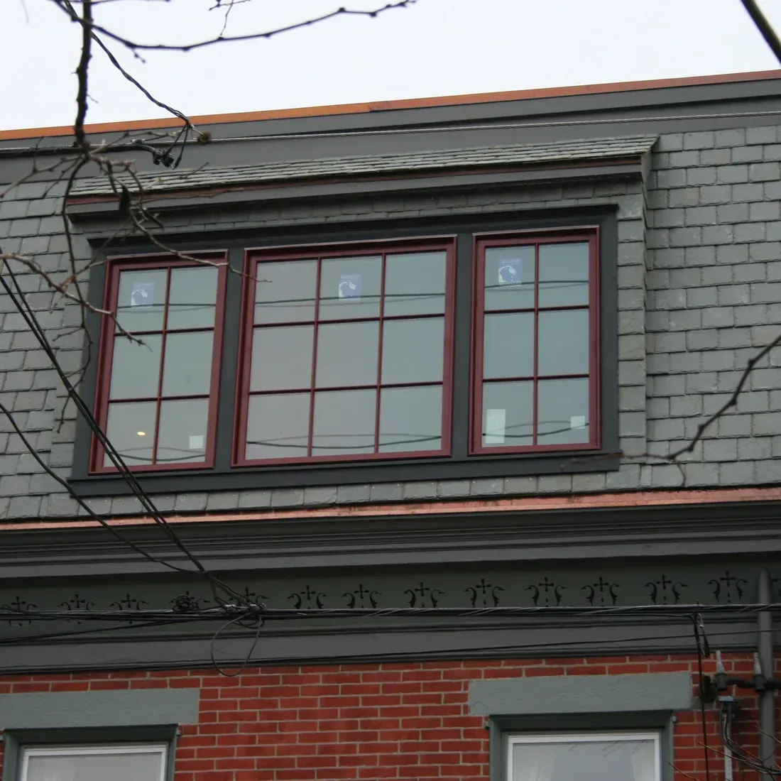 A brick building with a slate roof and two windows